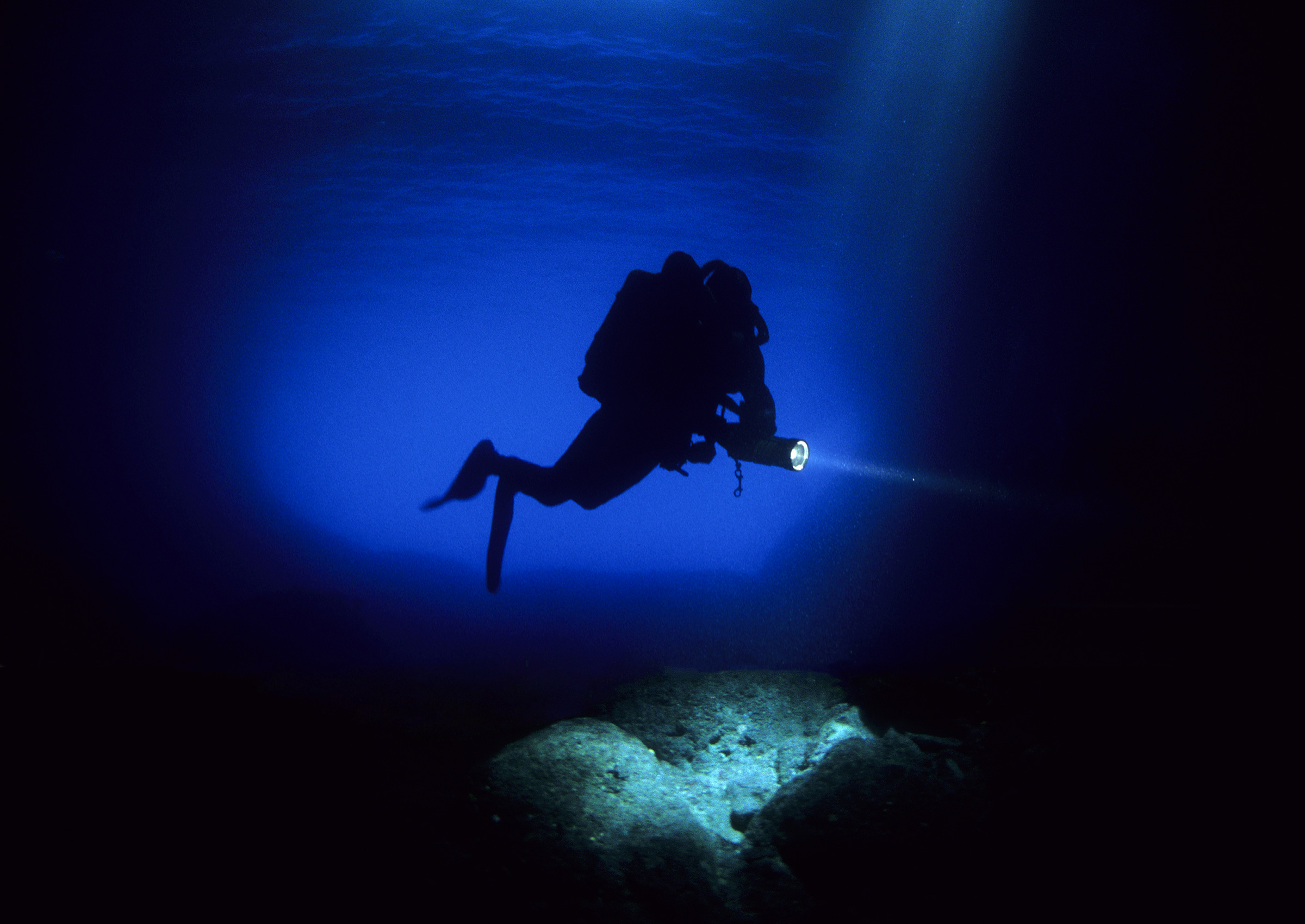 Technical diver moving through dark blue Adriatic water